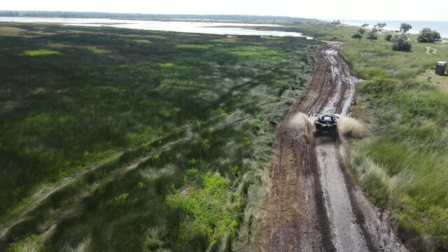 ATV across the field in the mud along the lake