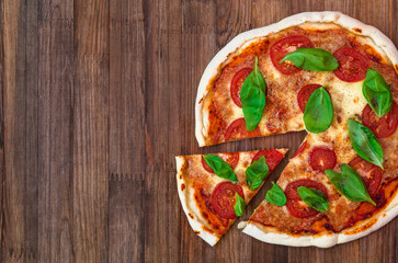 freshly baked Italian pizza with cheese and tomato sauce, garnished with basil leaves. ingredients with signatures. top view 