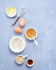 Ingredients  whole grain oat, coconut sugar, vanilla syrup, organic eggs on light blue background. Healthy recipe concept. Top view. Copy Space.