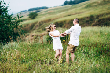 Fototapeta premium a guy with a girl in light clothes on the background of a green canyon
