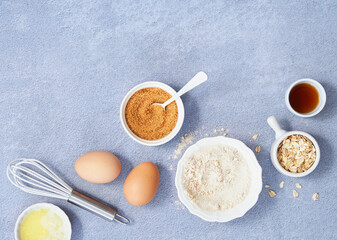 Fototapeta na wymiar Food background, Ingredients for homemade oat pancakes with whole grain oat, coconut sugar, vanilla syrup, organic eggs on light blue background. Healthy recipe concept. Top view. Copy Space.