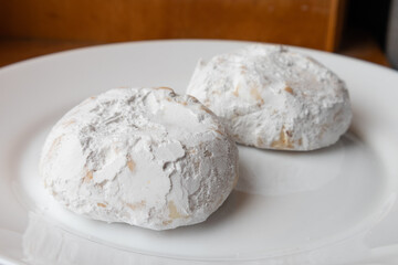 Fototapeta na wymiar Two Traditional Kourabiedes Greek Butter Cookies on a White Plate