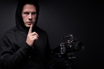 maniac filming victim on camera, watching, looking at camera, isolated on black studio background....