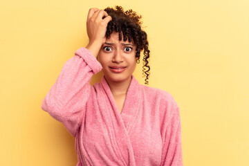 Young mixed race woman wearing a pink bathrobe isolated on pink background being shocked, she has...