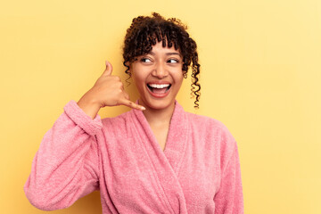 Young mixed race woman wearing a pink bathrobe isolated on pink background showing a mobile phone call gesture with fingers.