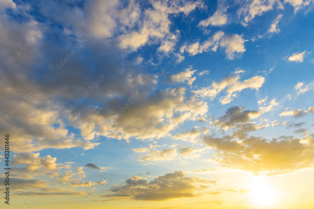 Wall mural sky blue and orange light of the sun through the clouds in the sky