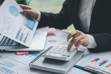 Financial Businesswomen analyze the graph of the company's performance to create profits and growth, Market research reports and income statistics, Financial and Accounting concept.