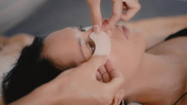 Woman master in the beauty salon work on eyelash extension to the client. Profession in the field of beauty services