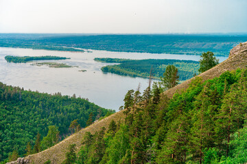 Panorama of mountains with a dense forest and the Volga River on the background, photographed from a height. Nature of Russia