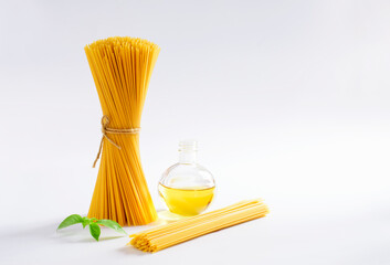 Top view of a bunch of bucatini or perciatelli - pasta, spaghetti with basil and vegetable oil on...
