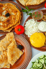 Homemade Romanian Food with grilled fish, polenta, pies, vegetables with red wine. Platter on camping.