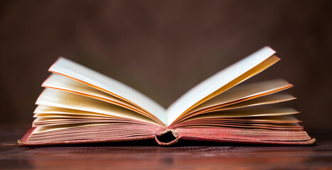 Old vintage book on the table in the classroom. Back to school, reading, learning concept. Web banner.