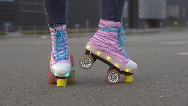 Woman's legs in a vintage quad roller skates with LED lights. Slow motion.