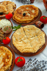 Homemade Romanian Food with grilled fish, polenta, pies, vegetables with red wine. Platter on camping.