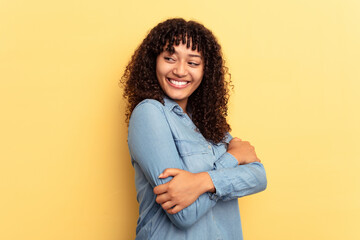 Fototapeta premium Young mixed race woman isolated on yellow background laughing and having fun.