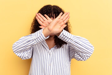 Young mixed race woman isolated on yellow background keeping two arms crossed, denial concept.