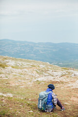Fototapeta premium a woman looks at a smartphone on top of a mountain on a hiking trip