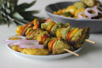 Chicken pineapple kebab. A dish of pieces of chicken and bell peppers marinated with coriander masala along with pineapple slices grilled on a skewer or spit using an air fryer
