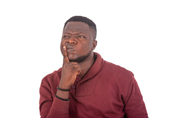 handsome young man is thinking while holding finger over mouth.