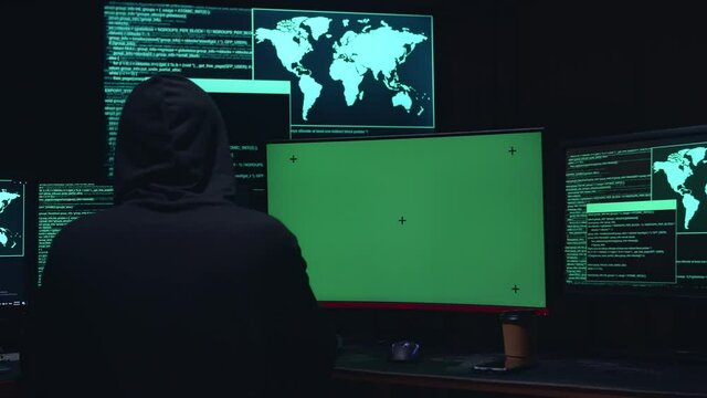 Hacker Hacking With Isolated Mock-Up Green Screen And Code On Multiple Computer Screens 
