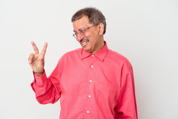 Naklejka premium Middle aged indian man isolated on white background joyful and carefree showing a peace symbol with fingers.