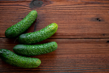 Fresh cucumbers on a dark wooden background.