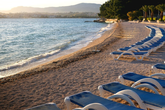 Deck chairs arranged on a beautiful beach near Split, Croatia. Selective focus.