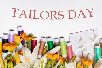 Greeting card with multi-colored threads and the text Tailors Day. For the holiday of a seamstress, tailor, atelier worker