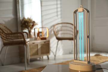 UV sterilizer lamp on table at home. Space for text