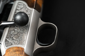 Metal trigger on hunting gun on black background