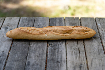 barra de pan encima de una mesa de madera en el campo al aire libre