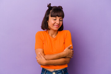 Young mixed race woman isolated on purple background hugs, smiling carefree and happy.