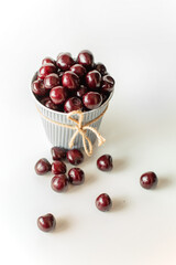 sweet cherries in a mug on a white background