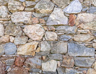 rough various colored stone wall closeup, seamless natural background