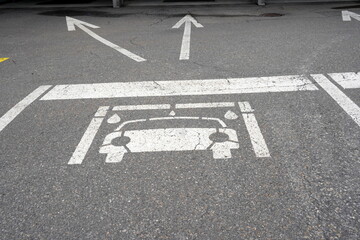 Pictogram of a car on the ground with two arrows showing direction to car wash facility. Close up...