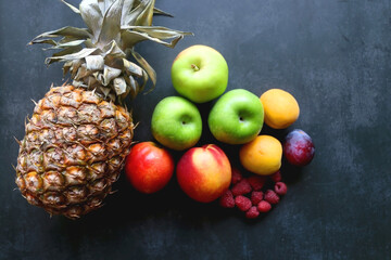 Various colorful fruit on dark background. Flat lay.