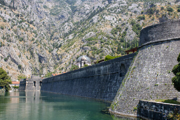 Fototapeta premium Medieval security wall surrounding the old town. Military tower. Fortress in mountain. Kotor Gurdic Gate and moat fortifications.