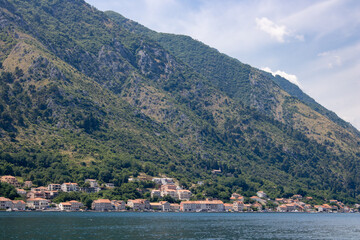 Landscape with blue sea and green mountains against the background of a clear sky. Panoramic beautiful view over the sunny city. Balkans on a wonderful summer day.