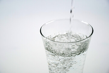 puring water into glass isolated on whtie background.