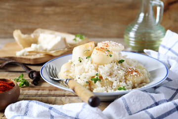Italian cuisine. Scallop risotto, olive oil and parmesan cheese