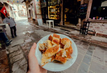 Fast food with turkish borek food, on street with people, some bars and small cafes