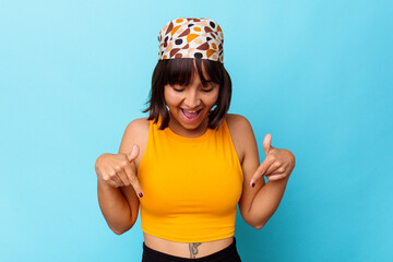 Young mixed race woman isolated on blue background points down with fingers, positive feeling.