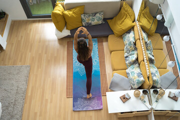 Young caucasian woman meditating at home with online video meditation lesson using laptop.
