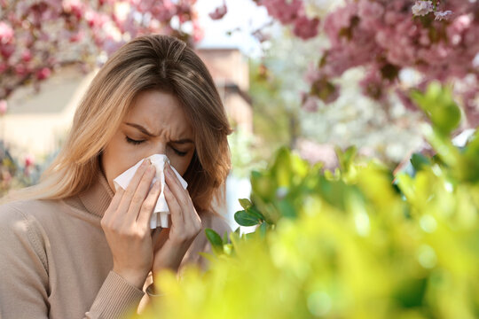 Woman suffering from seasonal pollen allergy outdoors