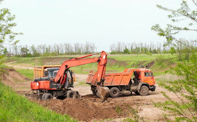 excavator in construction site on sunset sky background