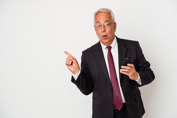 Senior business american man holding mobile phone isolated on white background pointing to the side