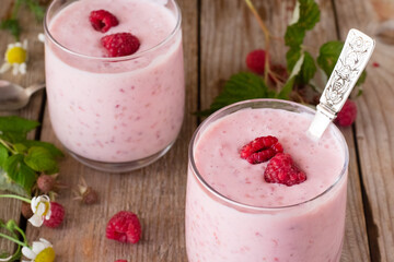 Yogurt with raspberries on wooden table