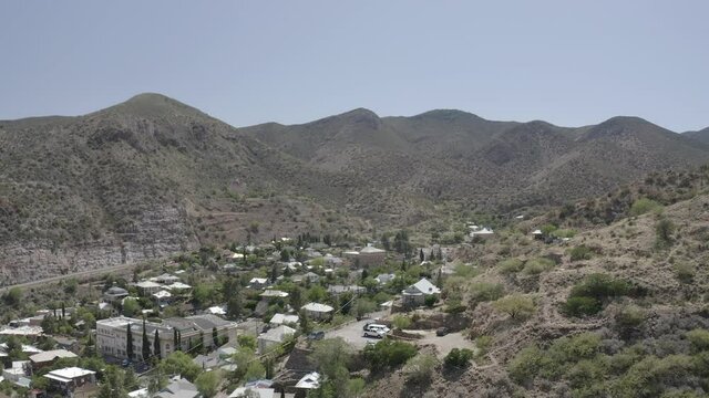 Aerial view of the town of Bisbee in Arizona. This small town is surrounded by mountains and has many building, homes, and trees. 