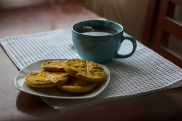 sopaipillas al horno con una taza de te, masa de harina mezclada con zapallo, snack chileno, fotografia de comida, somida casera