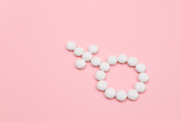 Obraz na płótnie Canvas Female Gender Symbol Made from White Pills - Women's Health and Medicine, Medicaments for Women, Lying on Pink Background. Copy Space